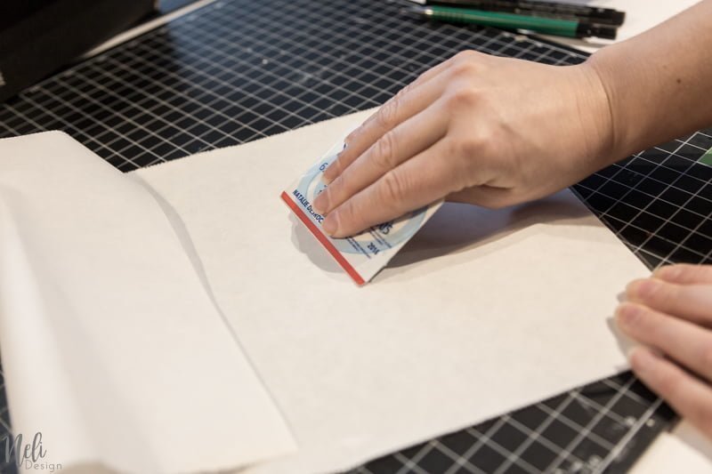 Installer le papier sur le tapis de coupe en lissant avec une carte de crédit