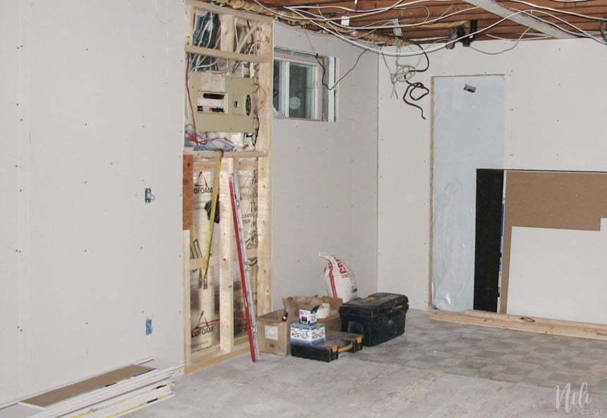 The wall is covered with drywall except the electrical panel