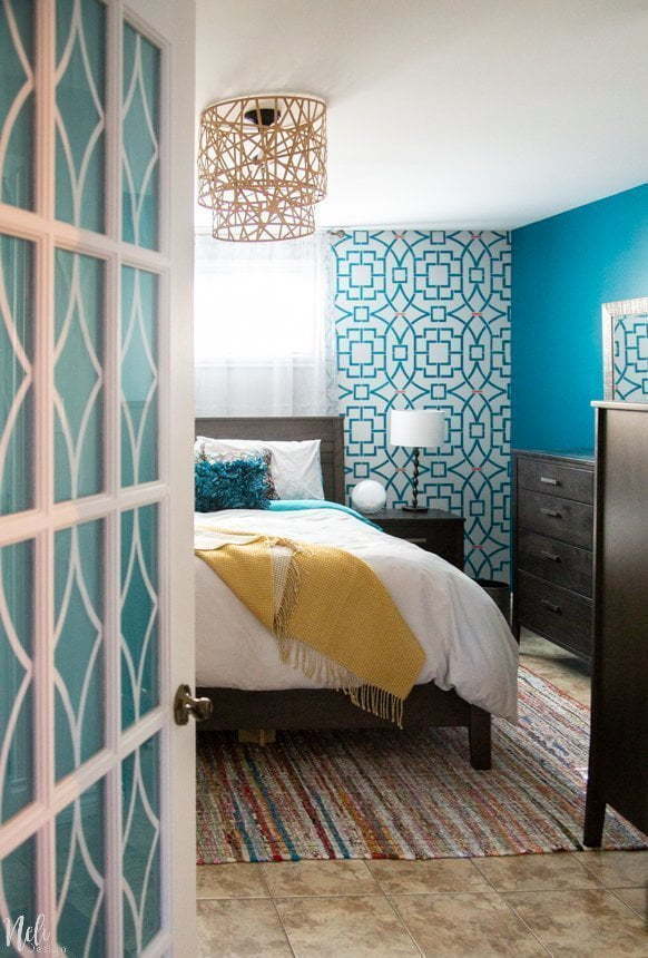 Get inspiration from this colorfull master bedroom makeover reveal. The $100 Room challenge is a great time to show a lot of ideas on how to makeover a bedroom on a budget. See the before and after pictures and find out how simple DIY crafts projects, stencilling and a change in the layout of the room can make a difference! Yes, you can have a bed in front of a window. #makeover #bedroom #roomreveal #teal