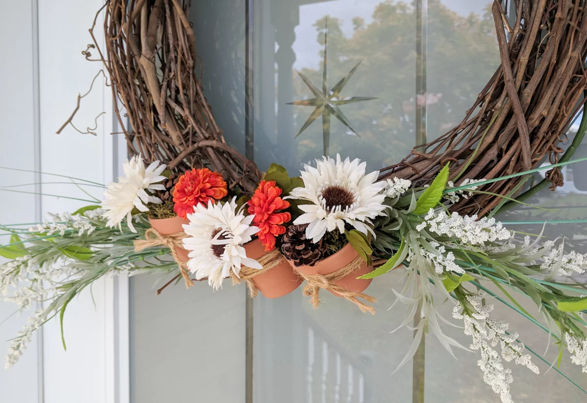 Get the tutorial on how I changed my spring/summer wreath for a fall wreath with mini terracotta pots in just a couple of minutes. This Dollar Store DIY is easy to make. You'll have a beautiful, natural and rustic look for your front door for autumn. #wreath #grapevine #flowers #frontdoor #porch #fall #autumn