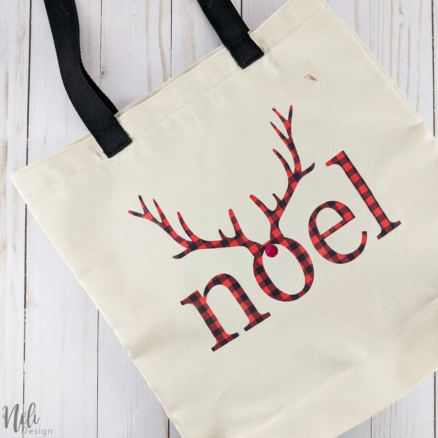 Bag with the writing Noel in red and black buffalo check with antlers.
