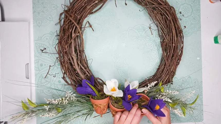 Removing the spring crocus flowers from the wreath to add the DIY chrysanthemum paper flowers to the grapevine wreath