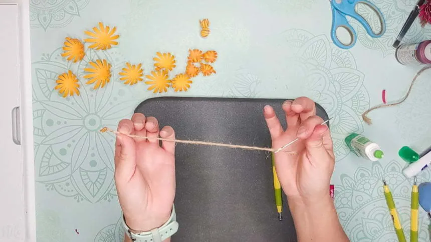 Threading the jute twine to make the DIY paper Chrysanthemum